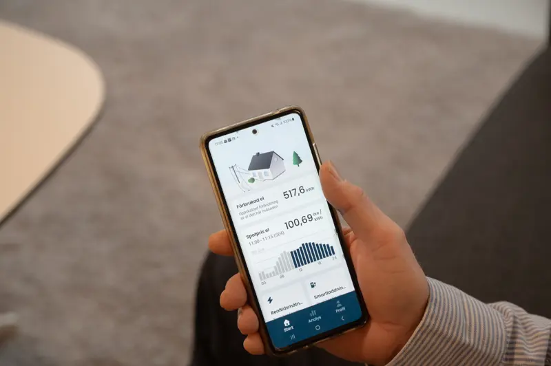En hand som håller telefon med Kraftringens app öppen